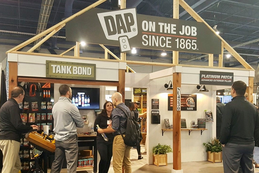 DAP trade show booth with team members and "On the Job Since 1865" signage