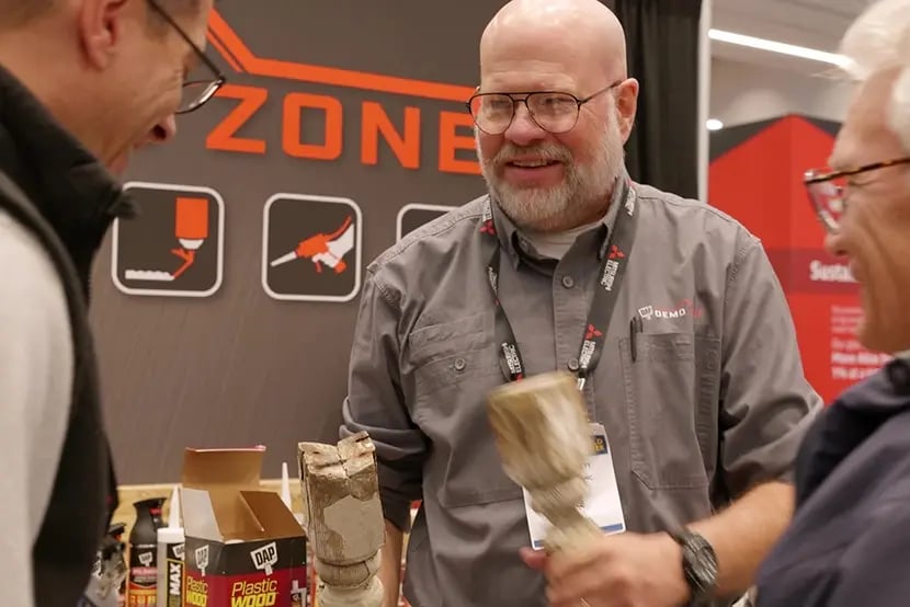 DAP expert demonstrating products and sharing application expertise with customers at a trade show booth.