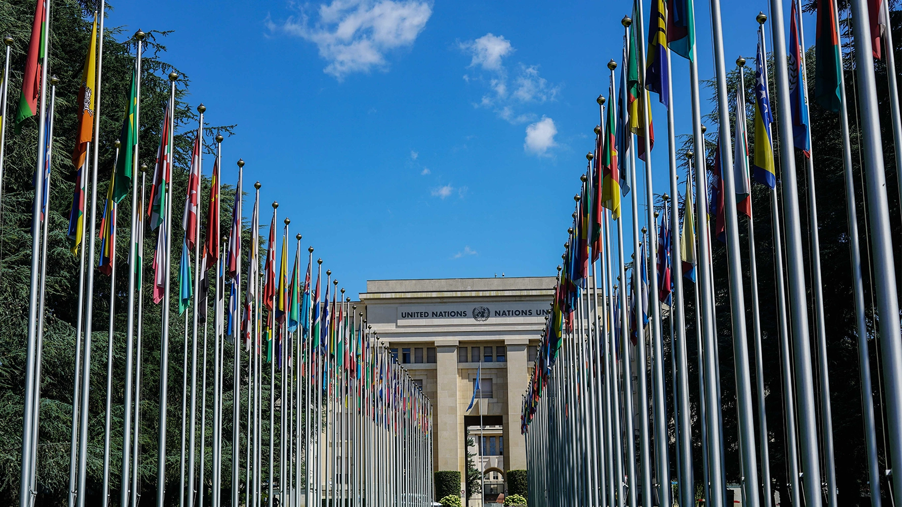 Multiple country flags in front of the United Nations building.