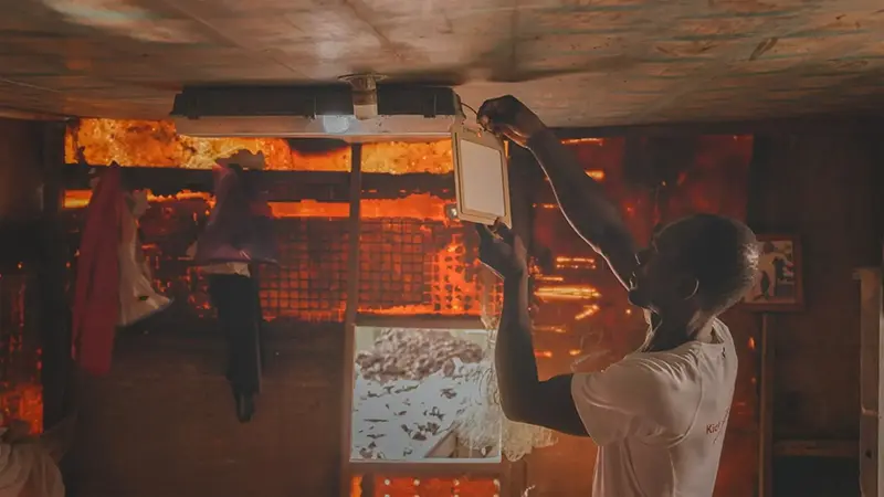 Man installing a Guardian spatial repellent in a home in Africa