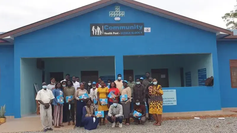 Health post at south sudan with people and workers standing in front