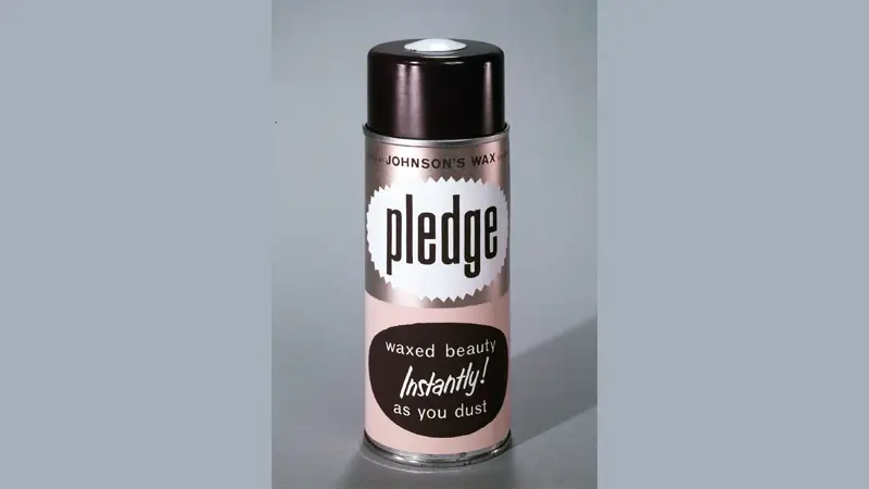 "Can labeled ""pledge"" stands on surface, promoting waxed beauty.