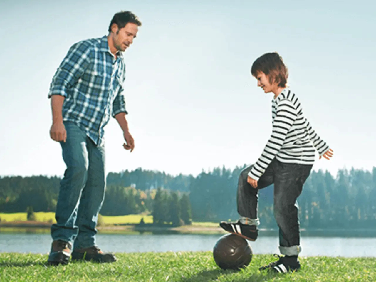 Padre e hijo juegan al fútbol afuera