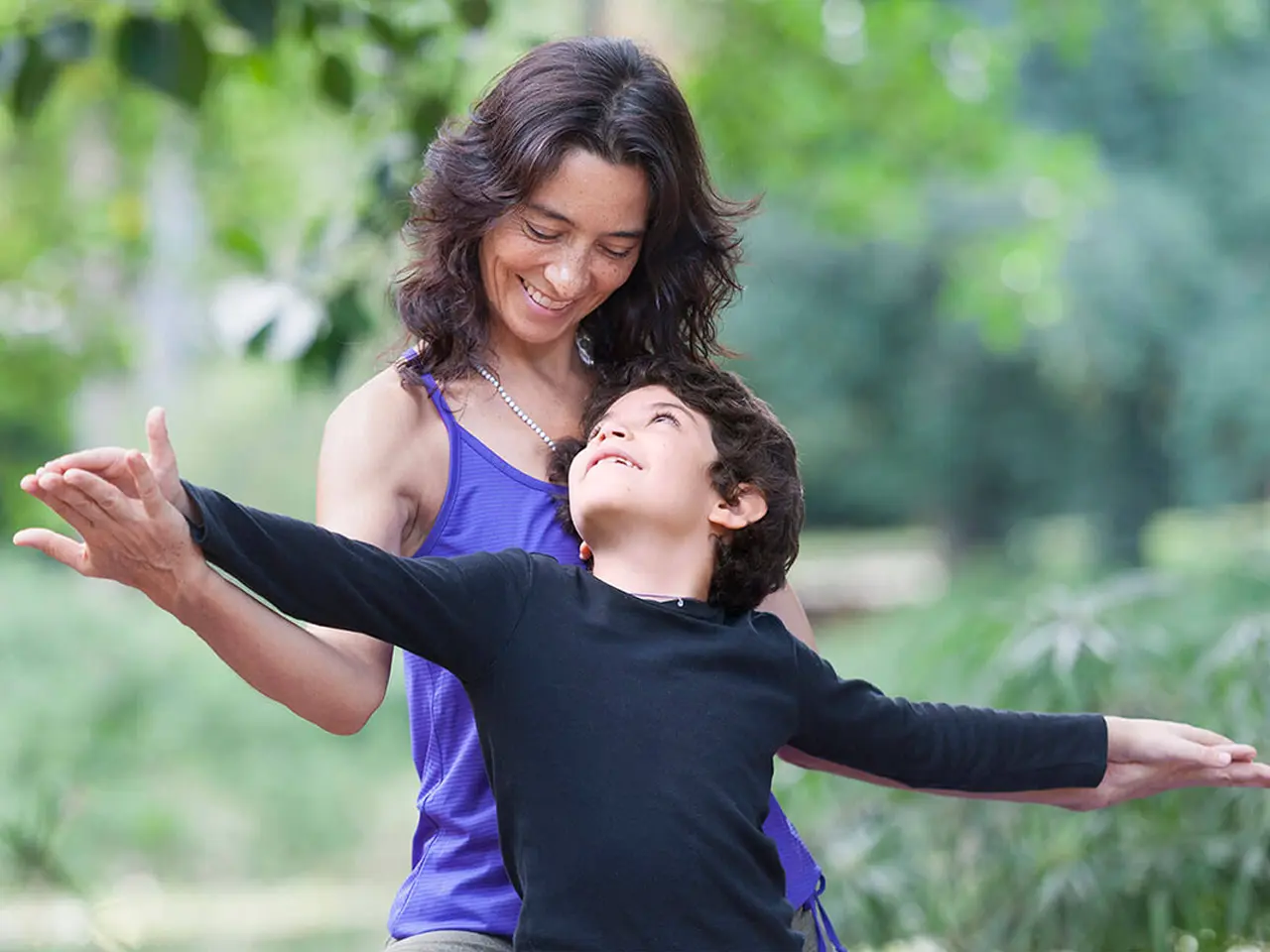 Mamá e hijo tomándose las manos con los brazos extendidos