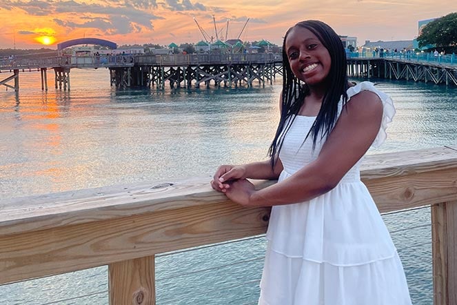 Gabrielle on pier at sunset, smiling