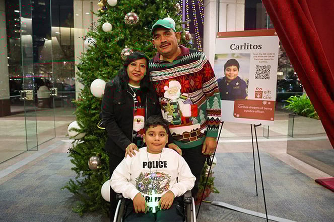 Carlito y su familia frente a un árbol de Navidad.