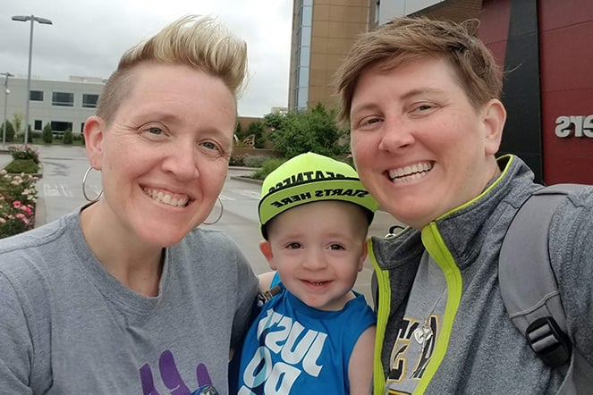 an infant smiling with two women