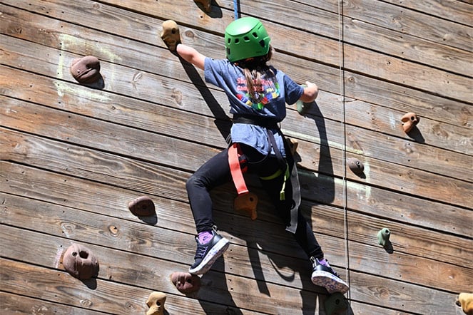 a young child on a rock climbing wall