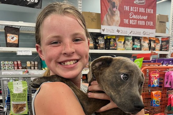 a girl holding a puppy