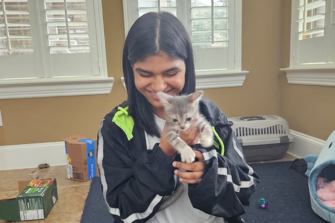 a teenager holding a kitten