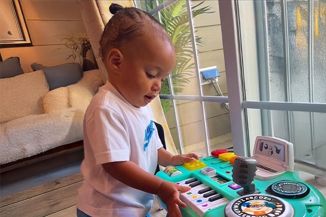 a toddler playing a colorful plastic piano