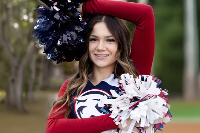a cheerleader with pom poms