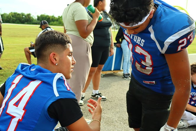 two football players talking in uniform