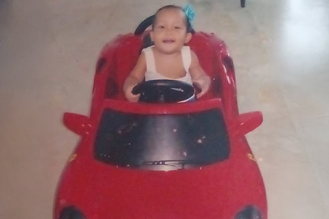 an infant sitting in a miniature car