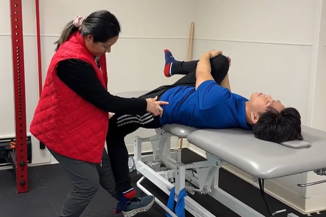 a physical therapist working with a patient on an examination table