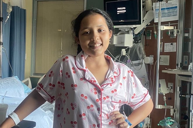 a smiling child in a hospital room