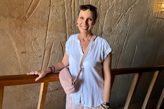 a woman standing in front of an stone carving