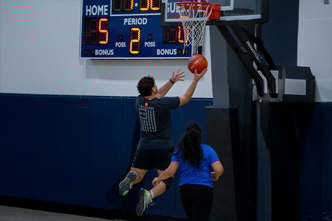 a basketball player jumping to make a shot into the hoop