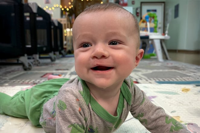 a baby smiling on a play mat