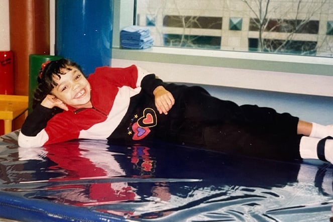 a vintage photo of a smiling child on a gymnastics mat