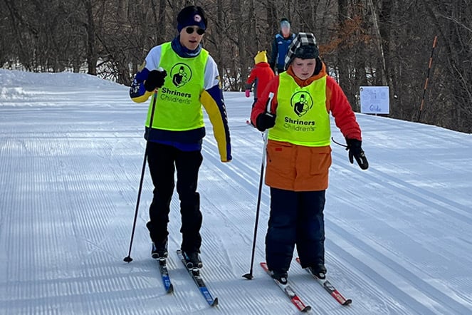 two skiers in visibility vests