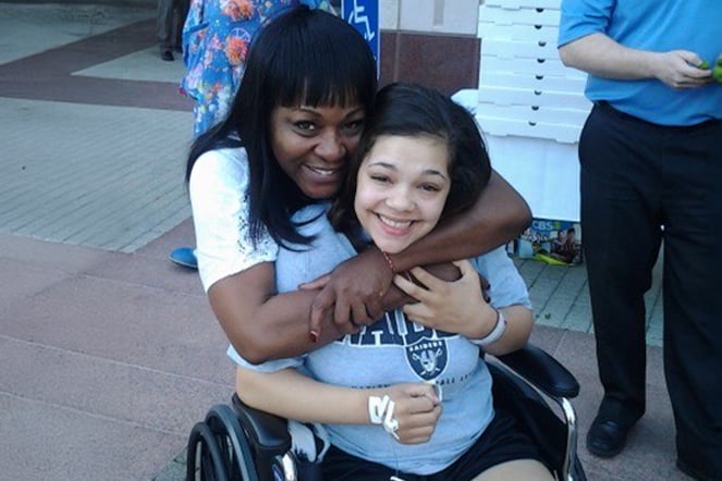 a woman hugging a child in a wheelchair