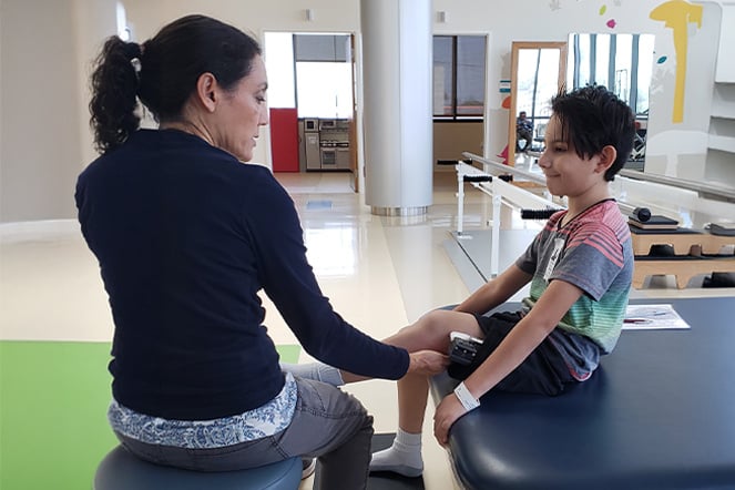 a young child and an adult in a physical therapy room