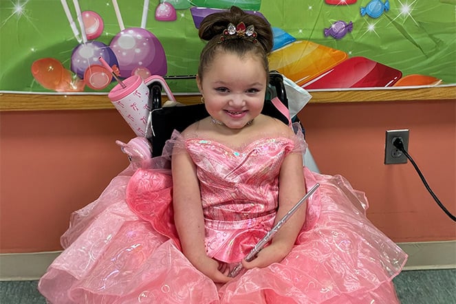 a young girl in a pink princess gown