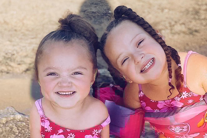 two children smiling at the beach