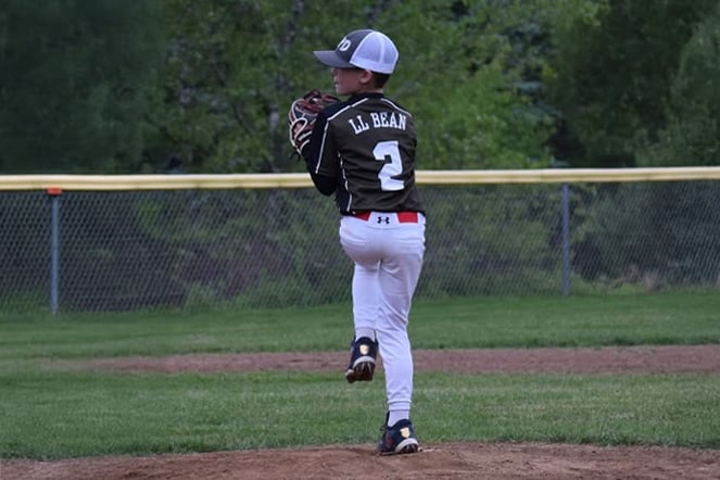 a youth baseball player throwing a pitch