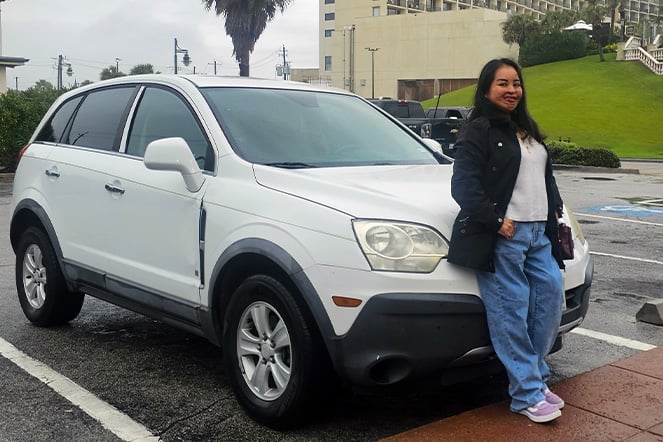 a woman leaning against an car