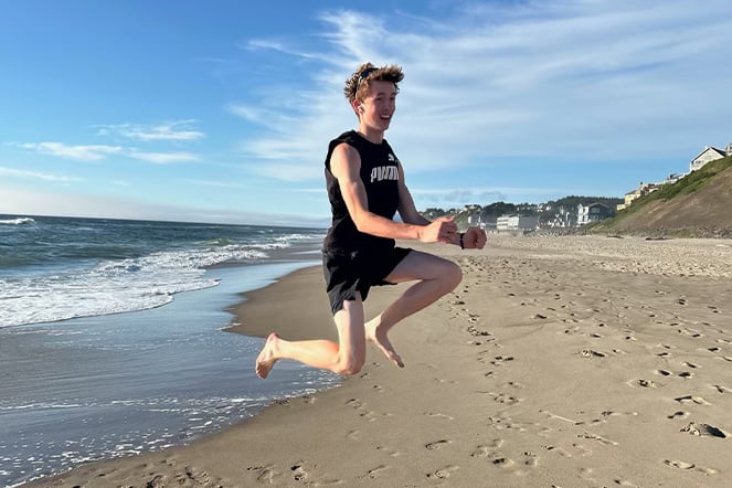 a child mid-jump at the beach