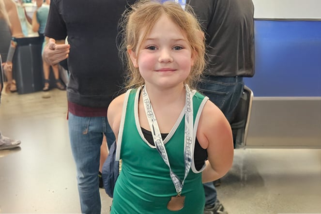 a child wrestler wearing a medal