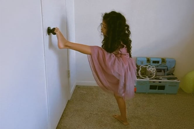 a child opening a door with her foot