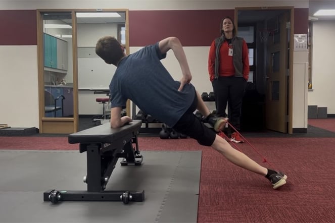 a child stretching in front of a physical therapist during a physical therapy session