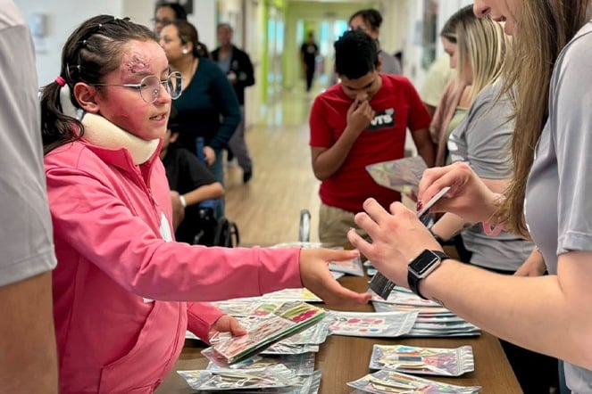 a child with burn scars receiving a pamphlet
