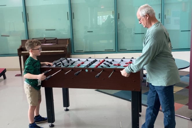an adult and a child playing foosball