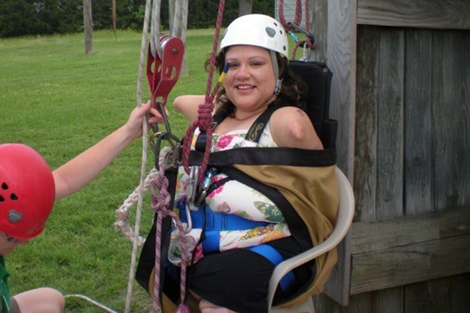 a child with phocomelia preparing to zip line