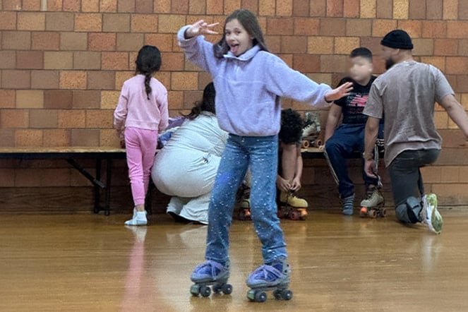 a child roller skating at a rink