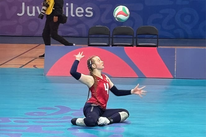 a sitting volleyball player preparing to spike a ball