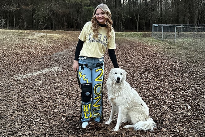 a child with a knee brace standing next to a dog