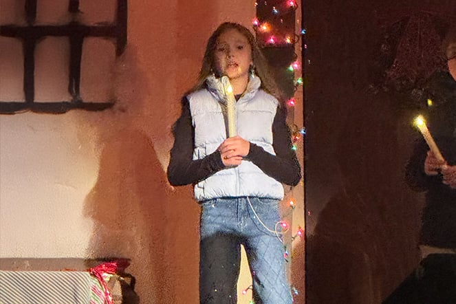 a child holding a candle and singing
