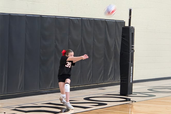 a child hitting a volleyball during a game