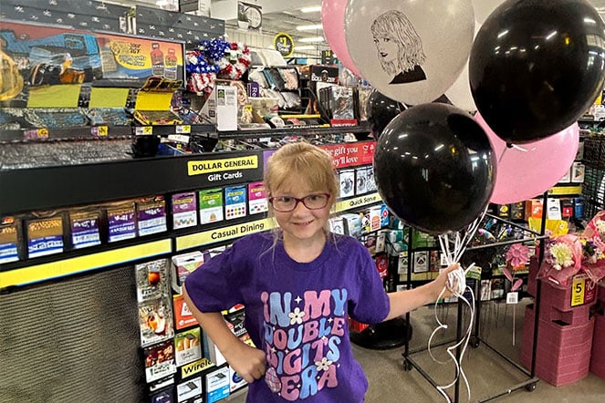 a child holding a bouquet of balloons