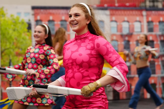 a woman preparing to spin a color guard flag