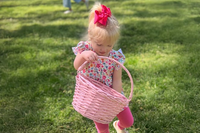 a toddler holding a colorful basket