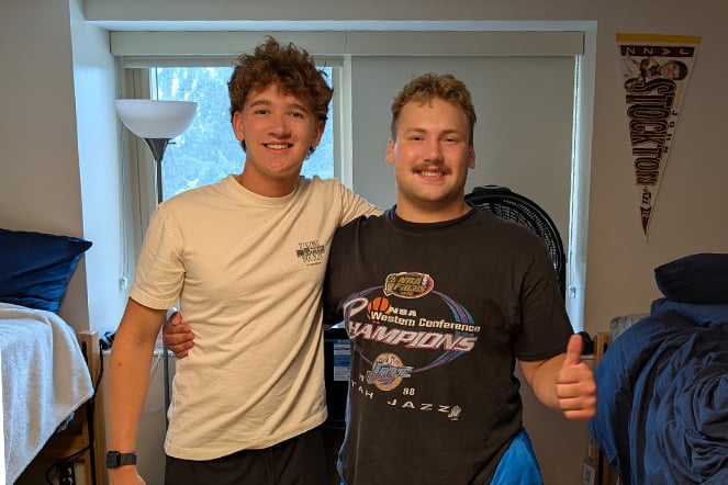 two teens standing in a dorm room