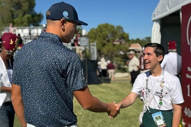 a man and a teenager shaking hands