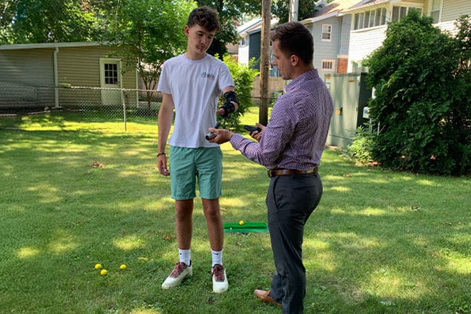 a teen having his prosthetic adjusted outside