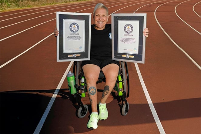 a woman in a wheelchair holding two plaques